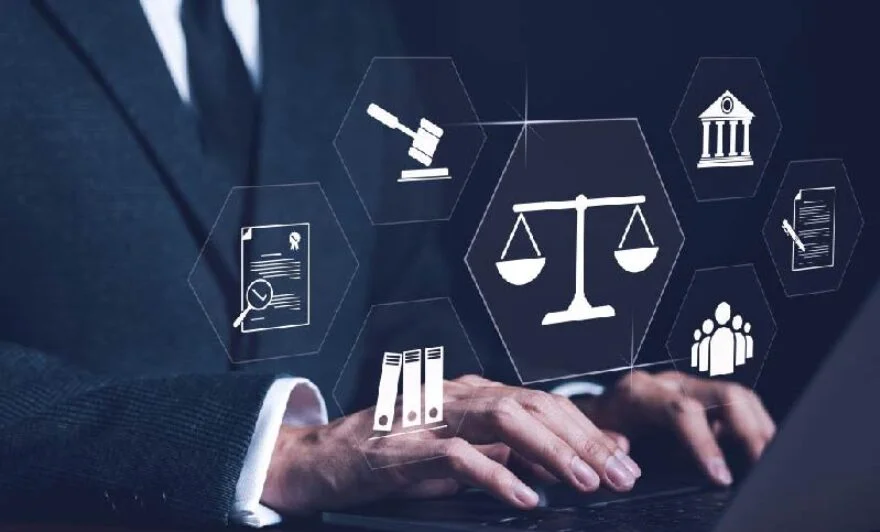 Person in a suit typing on a laptop with holographic legal icons (scales of justice, gavel, courthouse) floating around.