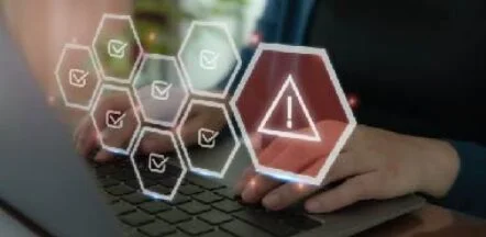 Hands on a laptop keyboard with holographic hex icons showing checks and a red warning triangle.