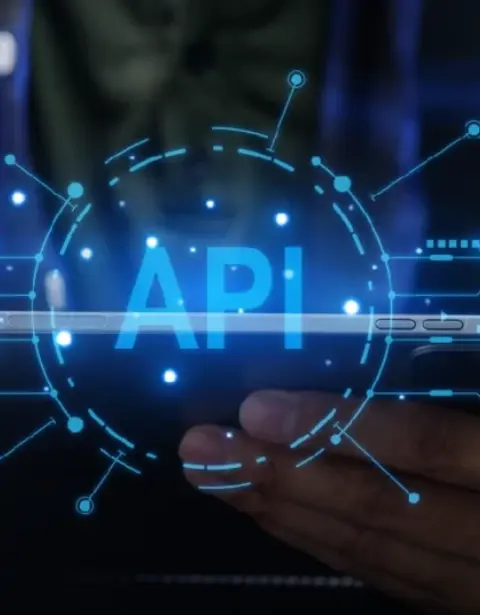Hands holding a smartphone with a glowing API graphic and circuit lines around it, symbolizing software integration.